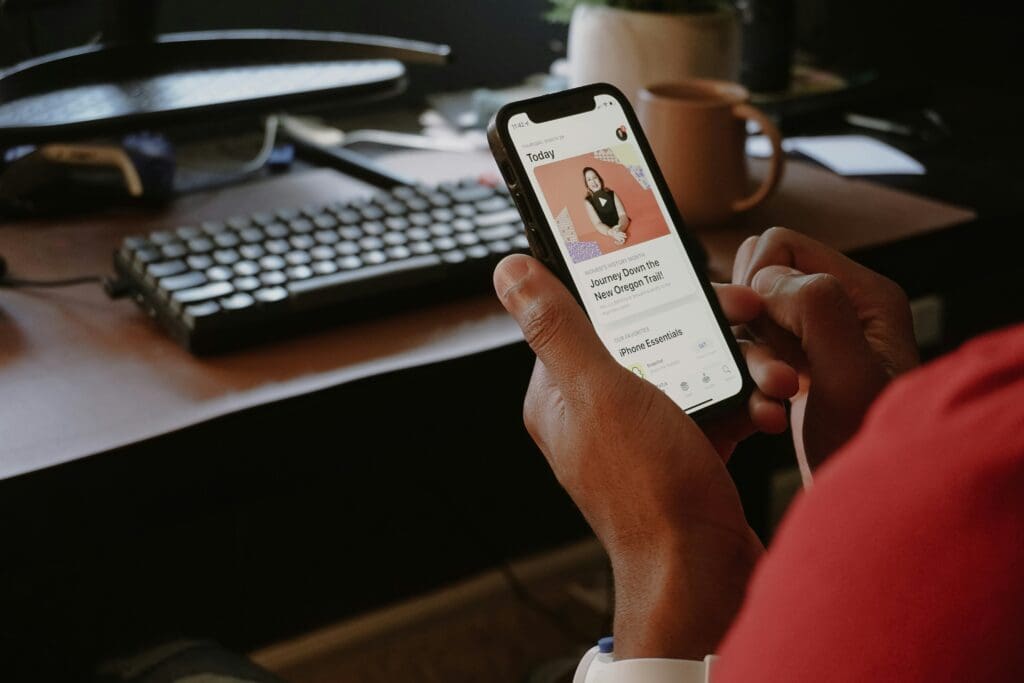 Person using smartphone at desk.
