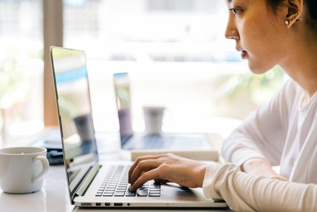 Person working on laptop at desk.