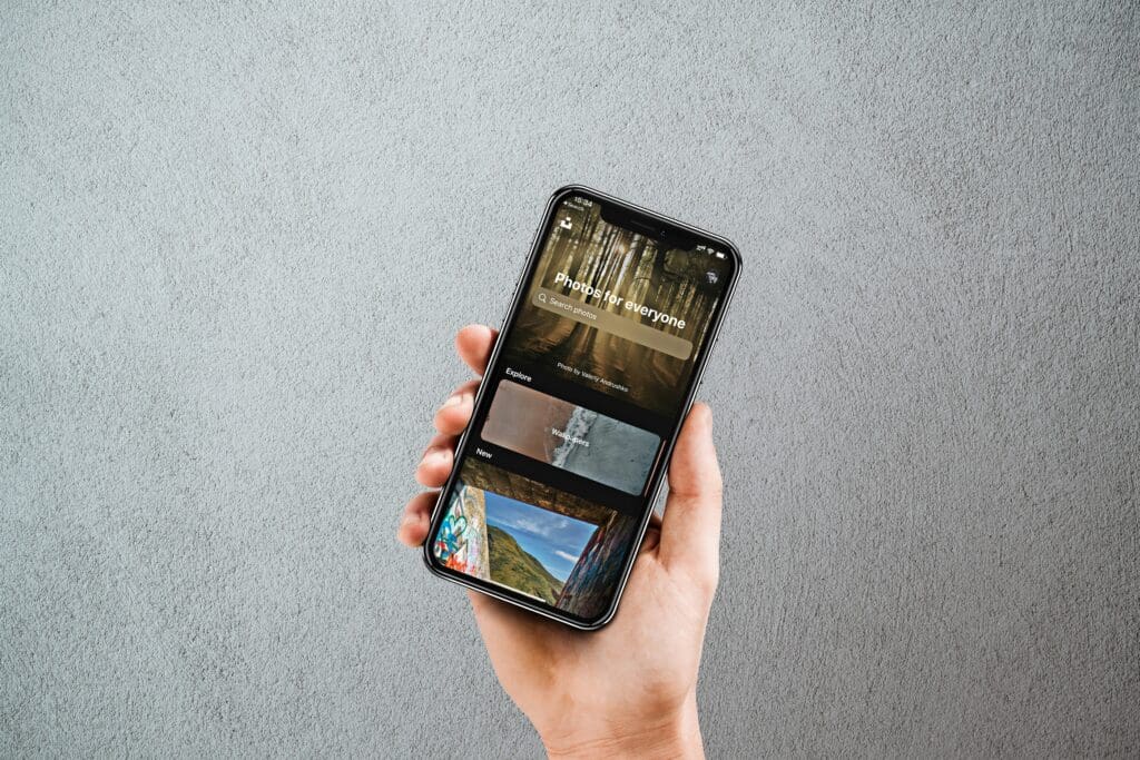 Hand holding smartphone displaying photos