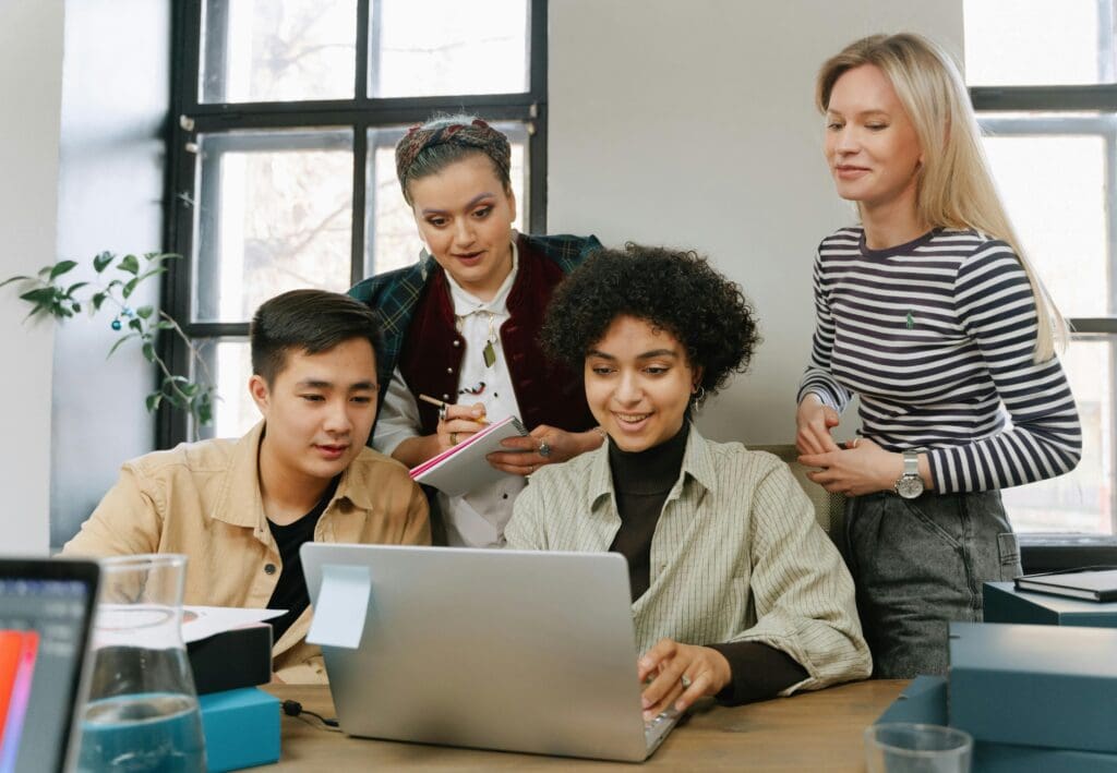 Group collaborating around a laptop.