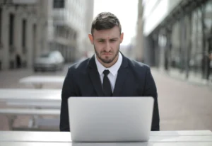 Businessman working on laptop outdoors.