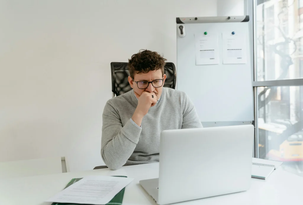 Person working at a desk, thoughtful.